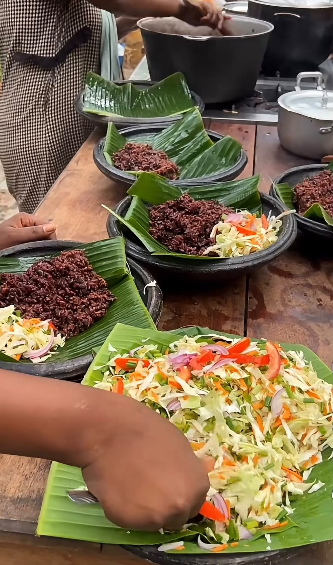 Ghanaian waakye served on banana leaves with fresh salad